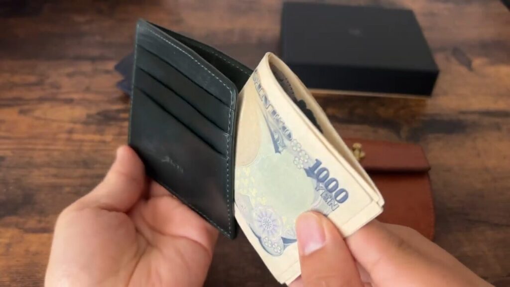 BRUSH(ブラッシュ)のFeather(フェザー)の札入れに入れるシーン