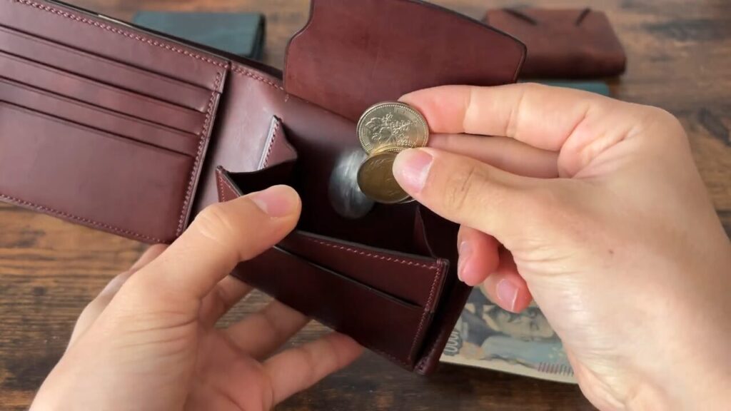 Lutece（リュテス）の二つ折り財布の小銭入れに入れるシーン