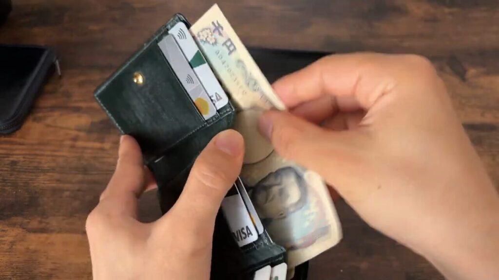 CRAFSTO(クラフスト)三つ折り財布の札入れから取り出すシーン