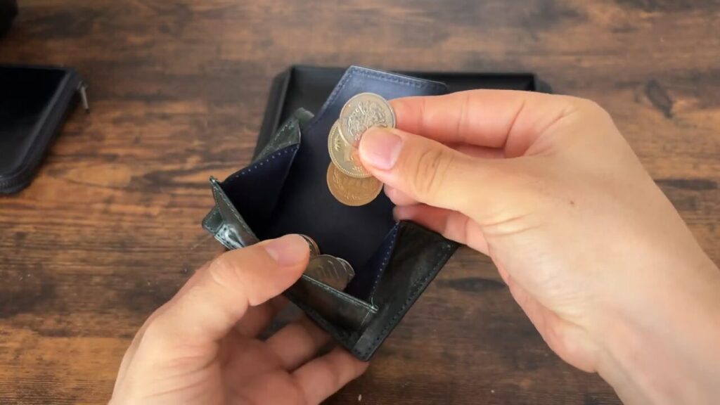 CRAFSTO(クラフスト)三つ折り財布 の小銭入れから取り出すシーン